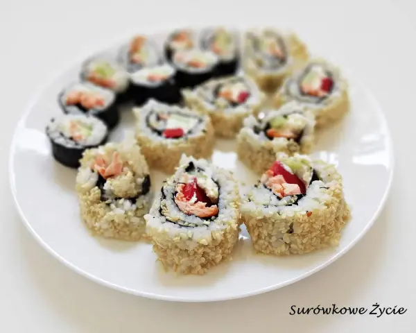 Talerz pełen sushi uramaki z łososiem, awokado i papryką, posypane sezamem. Pyszne i kolorowe rolki.