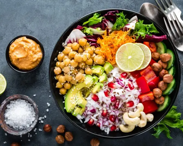 Kolorowy bowl z ciecierzycą, awokado, ryżem, papryką i granatem. Idealny przepis na zdrowy lunch.