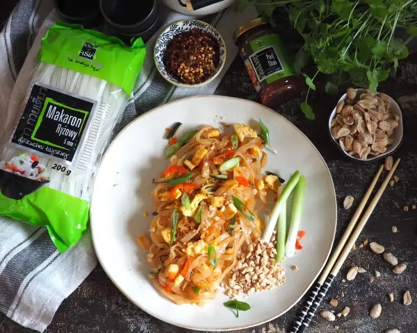 Pyszny pad thai z jajkiem, makaronem ryżowym i orzeszkami ziemnymi, gotowy do spożycia.