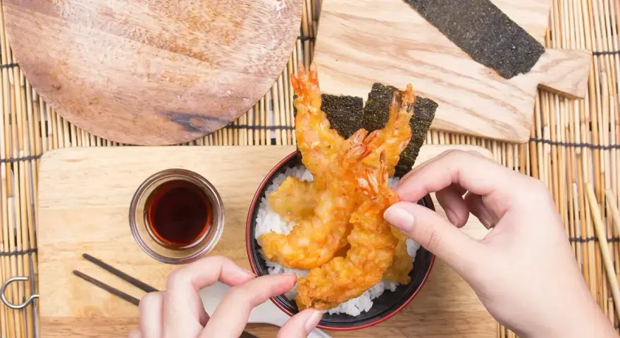 Gotowa tempura jak zrobić? Zobacz, jak pięknie wygląda chrupiąca krewetka w cieście na ryżu, gotowa do podania z sosem.