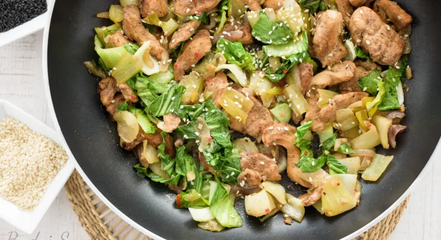 Smażony kurczak z pak choi, posypany sezamem, gotowy do podania.