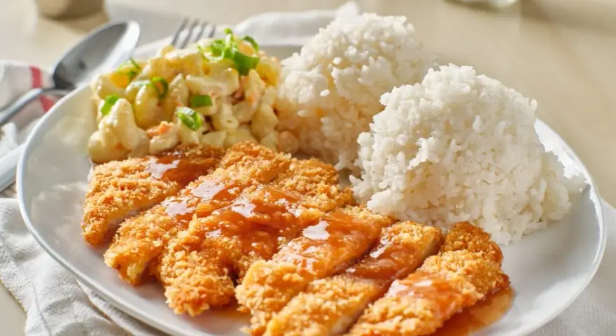Chrupiący kurczak w panko polany sosem, podany z ryżem i sałatką makaronową. Pyszny obiad!
