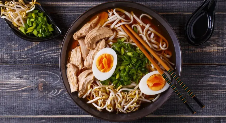 Miseczka aromatycznego ramenu z kurczakiem, jajkiem i kiełkami fasoli. Czy ramen jest zdrowy? Zależy od składników, ale ten wygląda apetycznie i pożywnie.