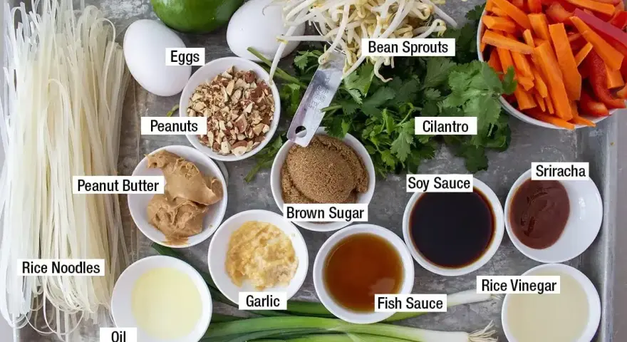 Składniki do sosu pad thai: makaron ryżowy, jajka, orzeszki ziemne, masło orzechowe, fasolka mung, marchewka, papryka, kolendra, sos sojowy, cukier brązowy, czosnek, olej, zielona cebulka, sos rybny, ocet ryżowy, sriracha.