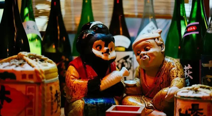 Figurki tanuki i starca z sake. Dowiedz się, jak pić sake, by poczuć japoński klimat.