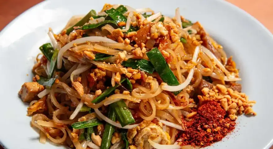 Pyszny pad thai z ryżowym makaronem, kiełkami, orzeszkami i chili. Idealny makaron do pad thai to cienki, płaski ryżowy.
