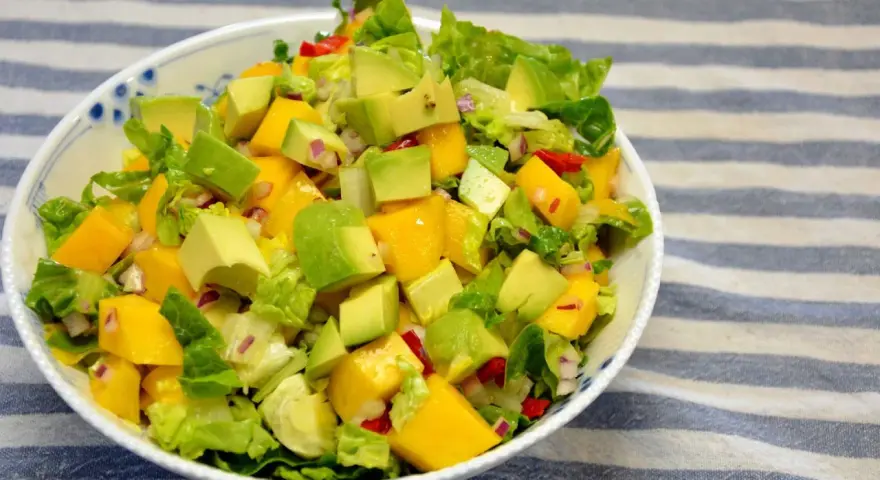 Orzeźwiająca sałatka z awokado, mango i czerwoną cebulą, polana lekkim sosem mango do sałatki.