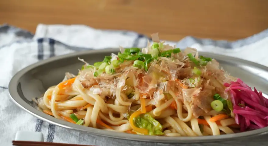 Udon z warzywami i szczypiorkiem, posypany płatkami katsuobushi. To właśnie katsuobushi co to jest, suszone płatki bonito, dodają daniu głębi smaku.