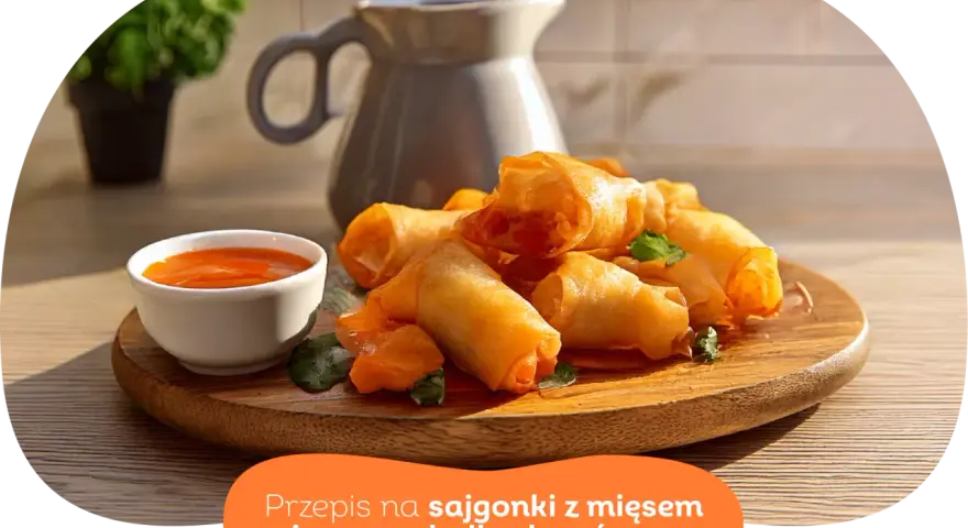 Chrupiące wege sajgonki z warzywami i sosem słodko-kwaśnym na drewnianej desce. Idealne na przekąskę.