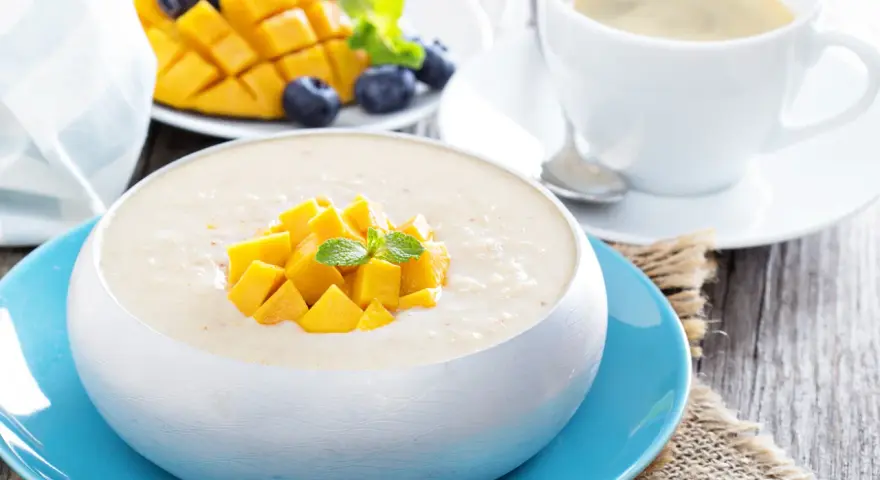 Pyszny deser z mango, jagodami i kawą. Ten mango smak to idealny początek dnia.