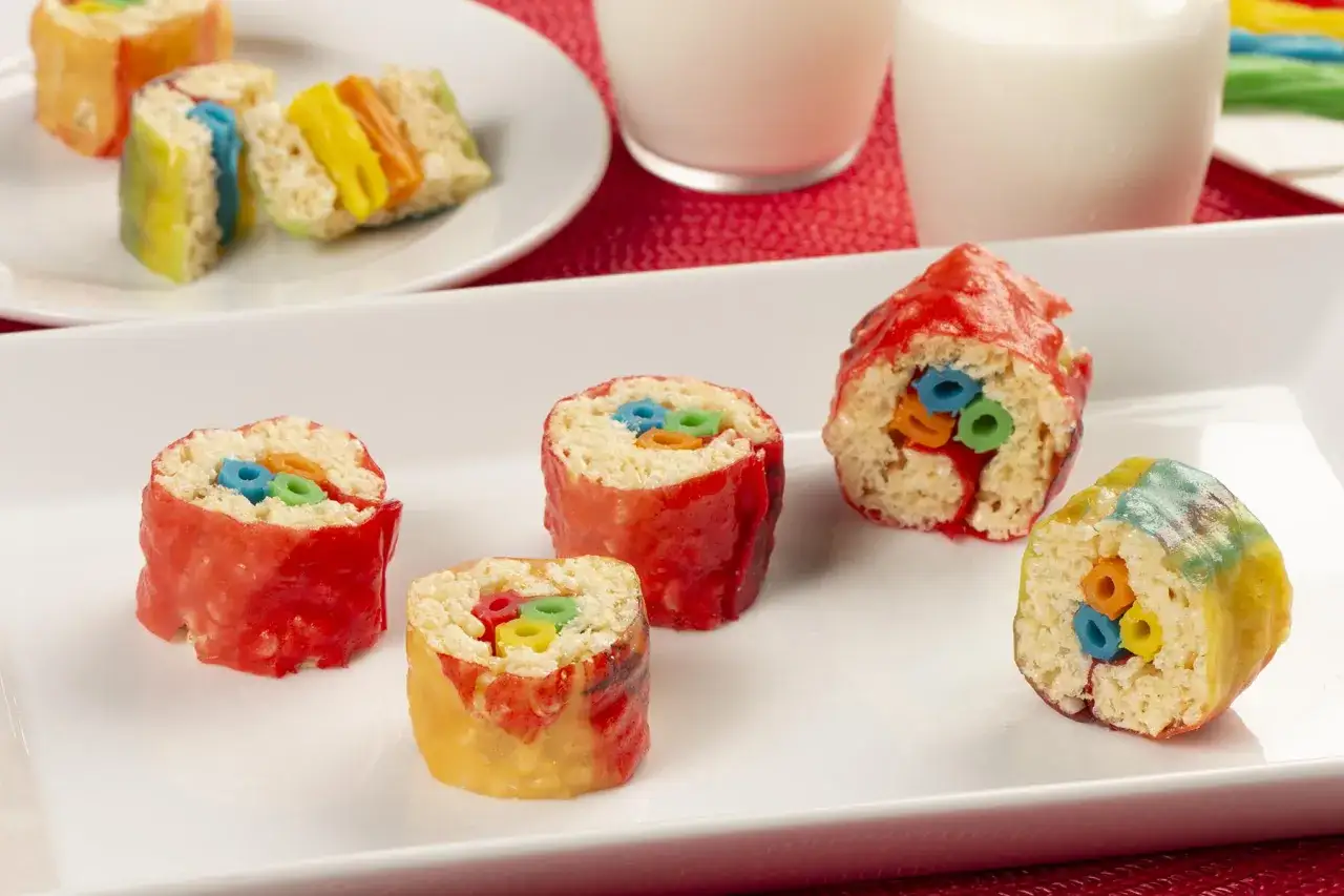 Kolorowe sushi owocowe z chrupiących płatków ryżowych, oblane lukrem, z kolorowymi kółeczkami w środku.