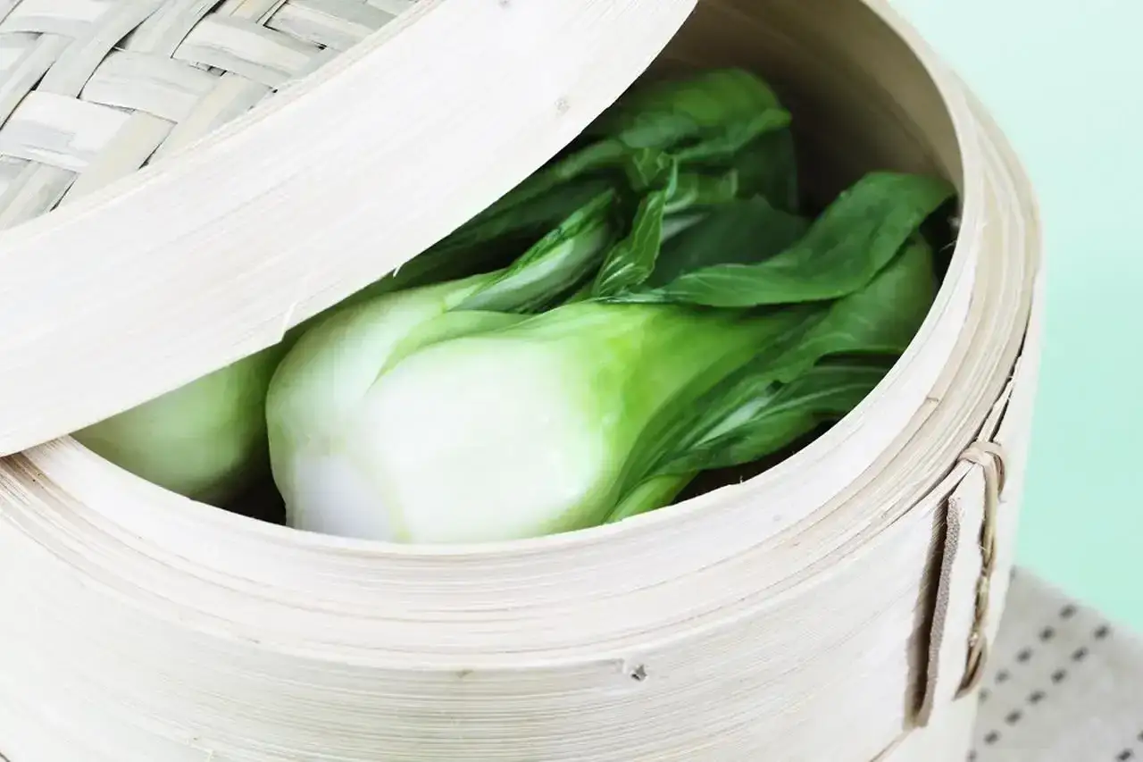 Świeża kapusta pak choi w bambusowym parowniku, gotowa na pyszne przepisy.