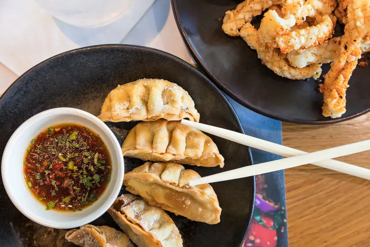 Złociste pierożki gyoza z sosem i chrupiące kalmary – idealne, co podać oprócz sushi.