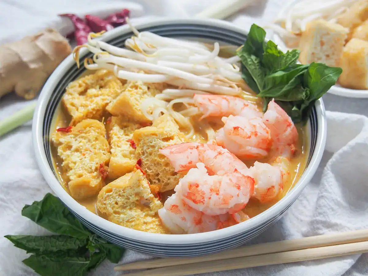 Aromaticzna zupa laksa z krewetkami, tofu i kiełkami fasoli. Idealny przepis na rozgrzewający posiłek.