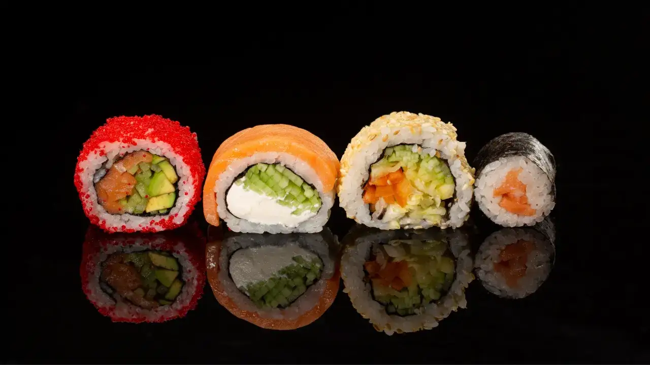 Cztery rolki sushi: z łososiem i awokado w ikrze, z łososiem i serkiem, z sezamem i warzywami, oraz maki z łososiem. Idealne, by zdecydować, ile sushi na osobę zam&oacute;wić.