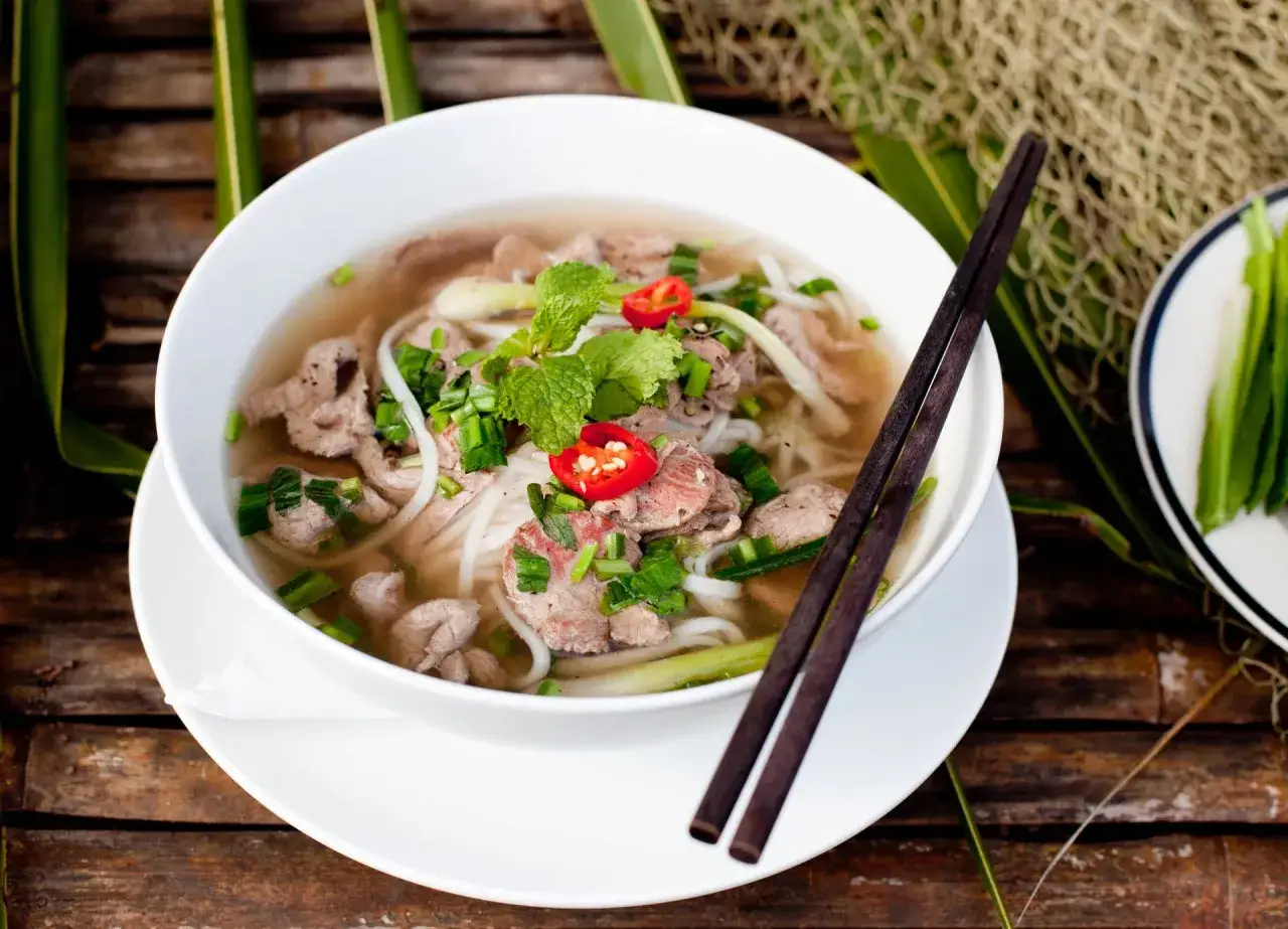 Aromatic zupa pho przepis oryginalny z cienkim makaronem ryżowym, plastrami wołowiny, świeżą miętą i chili.