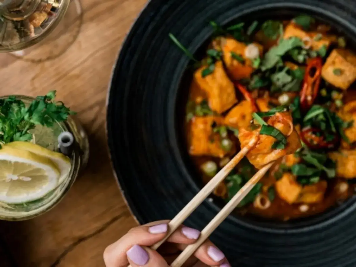 Pikantne tofu w sosie z chili i kolendrą – idealne, co podać oprócz sushi. Obok drink z cytryną i miętą.
