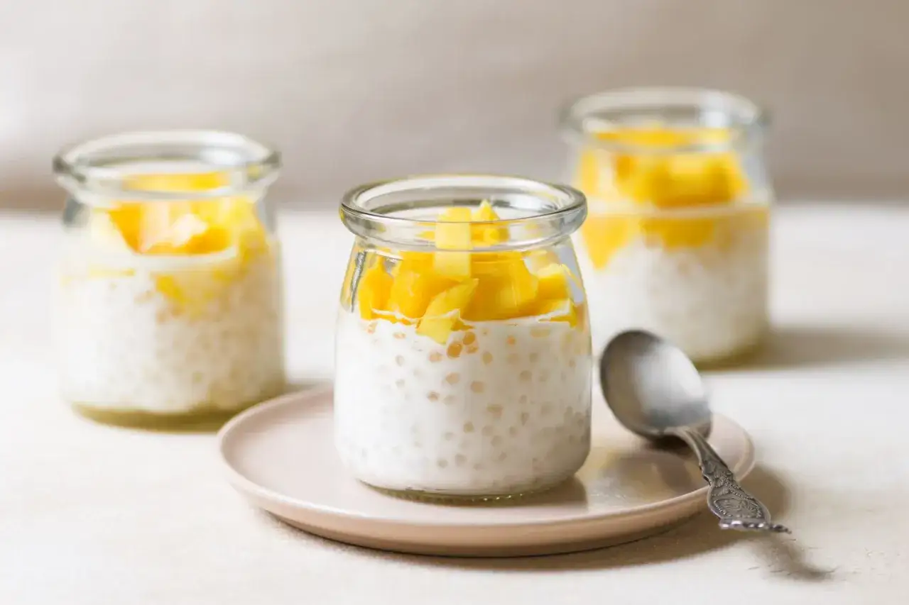 Słodka tapioka z mlekiem kokosowym i kawałkami mango w słoiczkach. Idealny deser na upalne dni.