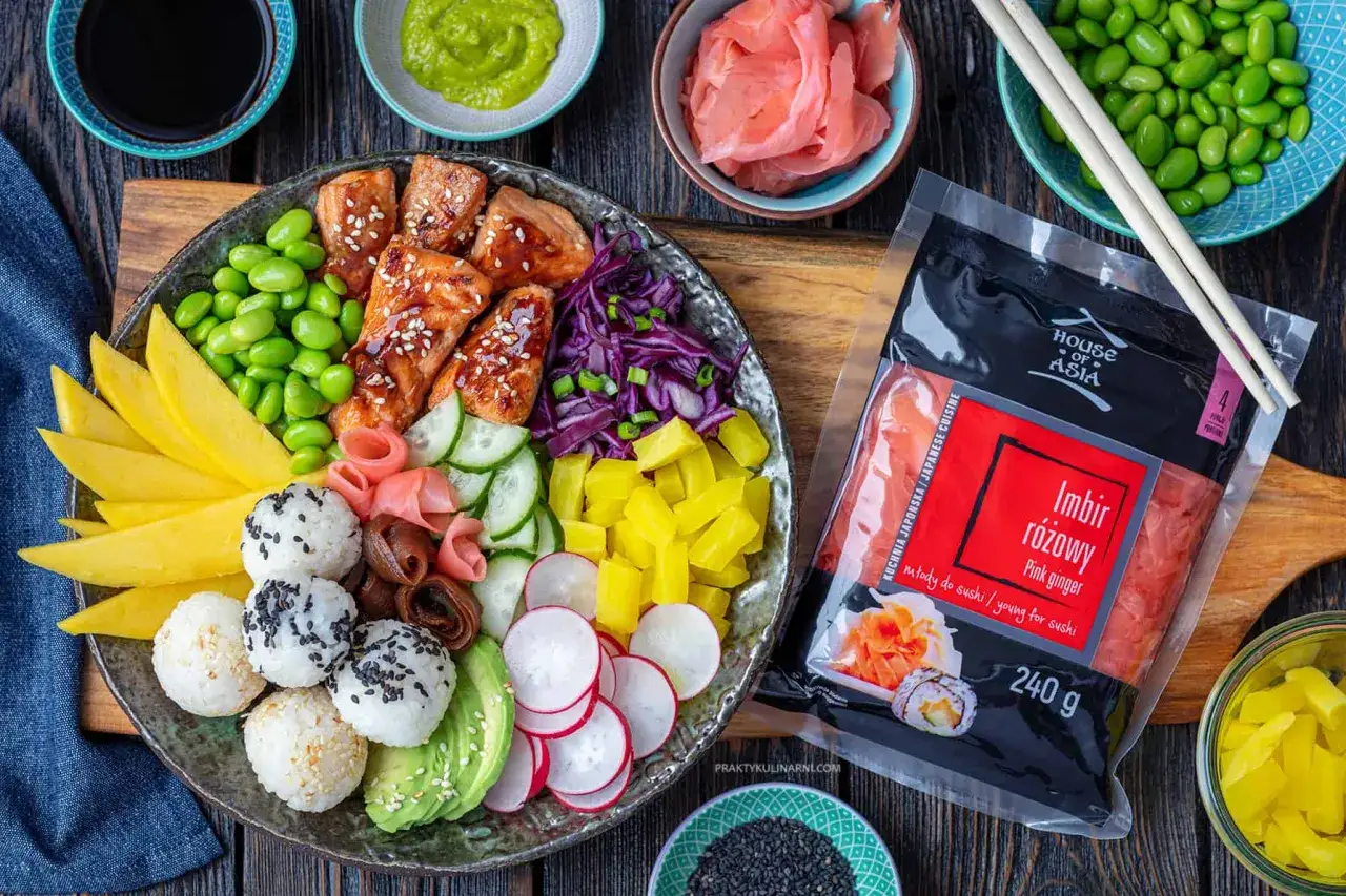 Kolorowa miska z ryżem, łososiem, edamame, mango, awokado i warzywami. Obok opakowanie różowego imbiru, idealne na pomysły na sushi.
