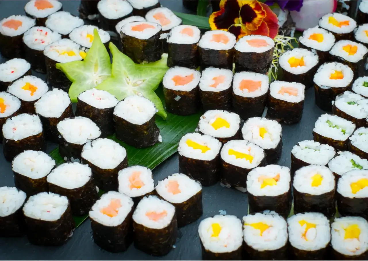 Mn&oacute;stwo sushi z łososiem, mango, og&oacute;rkiem i krabem. Idealne warzywa do sushi na talerzu.