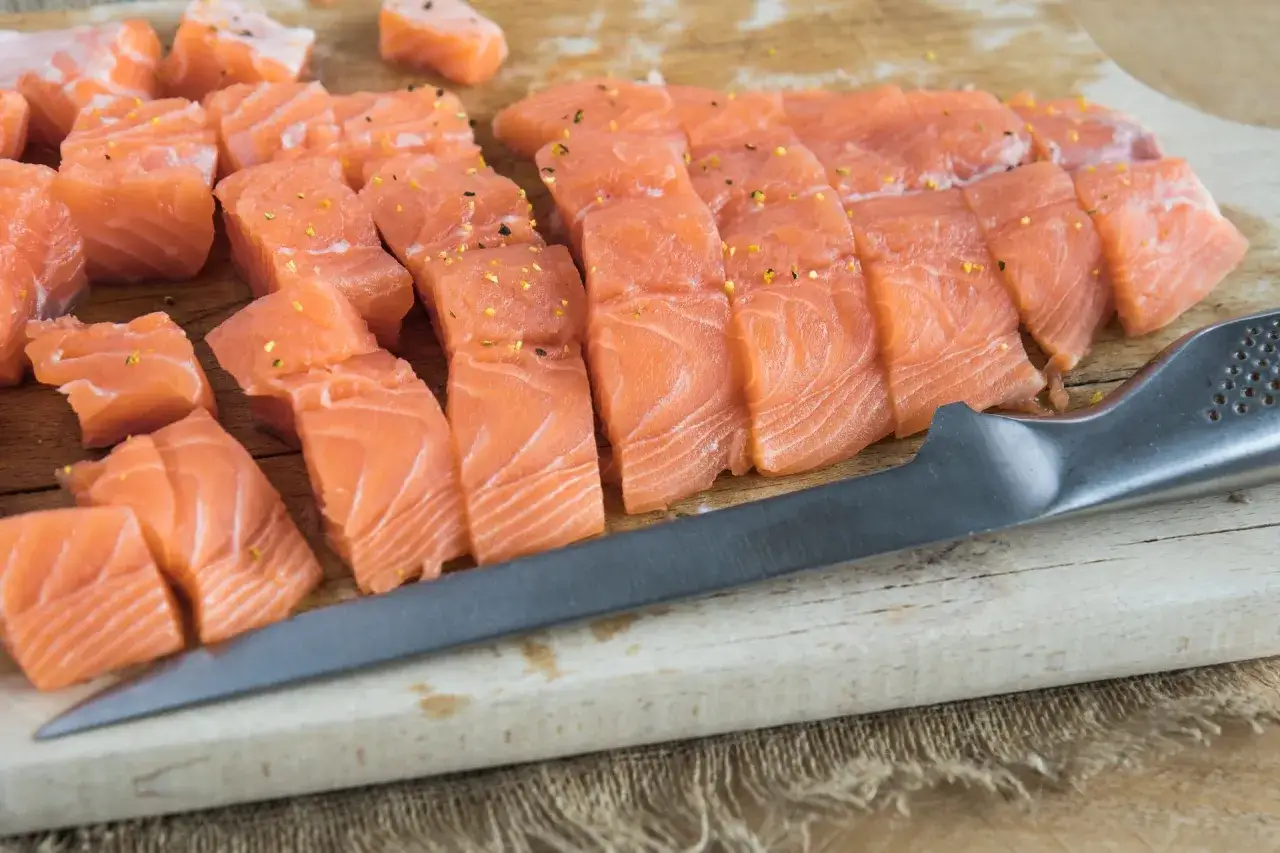 Idealny łosoś do sushi, pokrojony w kostkę i plastry, doprawiony. Gotowy do przygotowania pysznych rolek.
