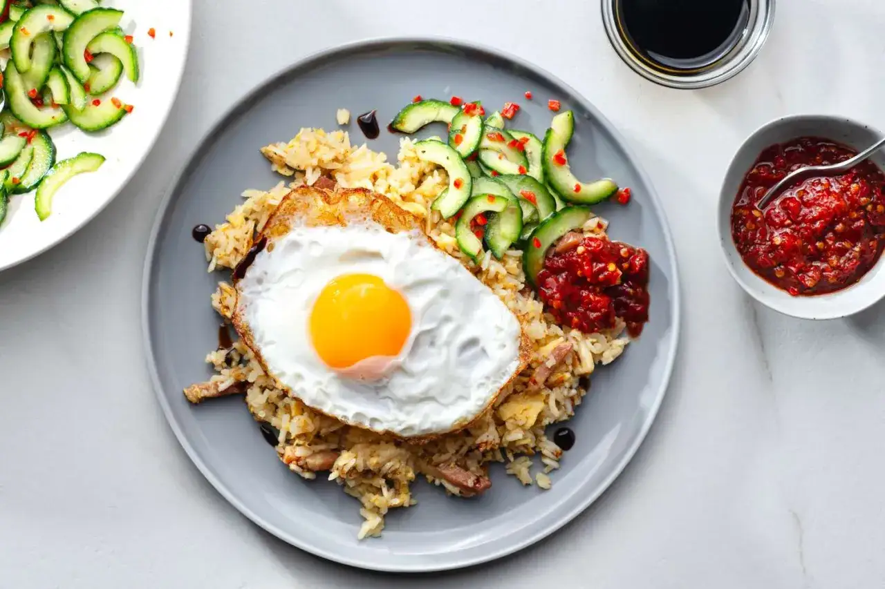 Nasi goreng z jajkiem sadzonym, ogórkiem i pikantnym sosem. Idealny na szybki obiad.