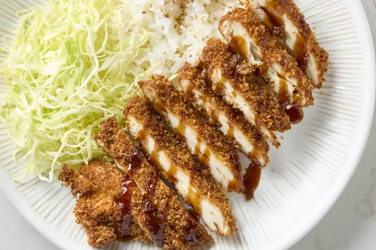 Chrupiące kotlety z kurczaka w sosie, ryż i surówka z kapusty. Idealny tonkatsu przepis na obiad.