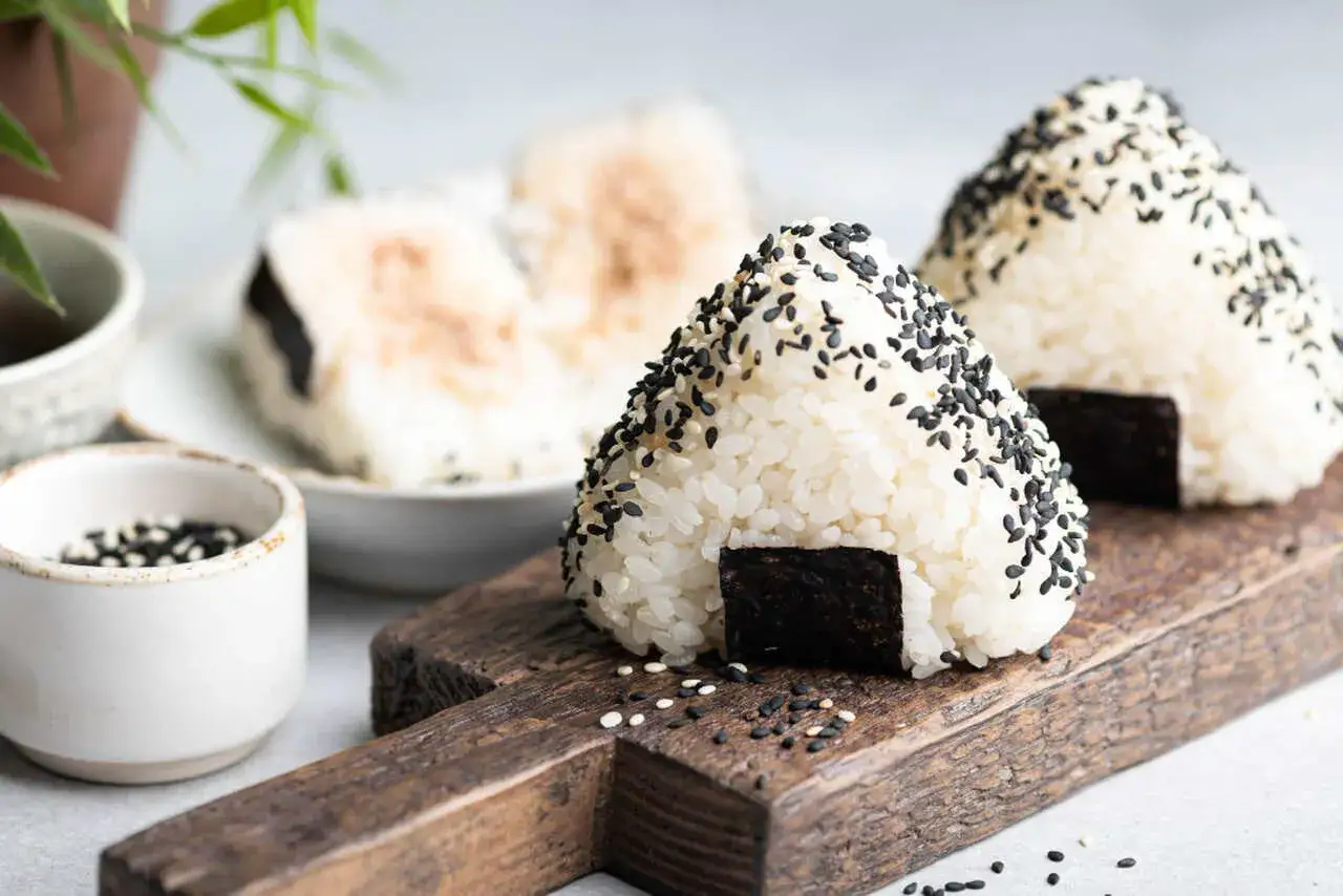 Tr&oacute;jkątne onigiri z ryżu, posypane czarnym sezamem, z kawałkiem nori. Idealne na przekąskę.