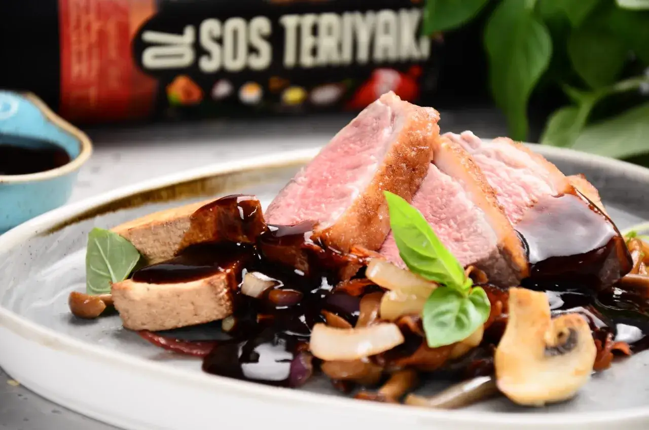 Soczysta kaczka w sosie teriyaki, podana z grzybami i cebulą. Danie wygląda jak kaczka w 5 smakach, idealne na specjalną okazję.