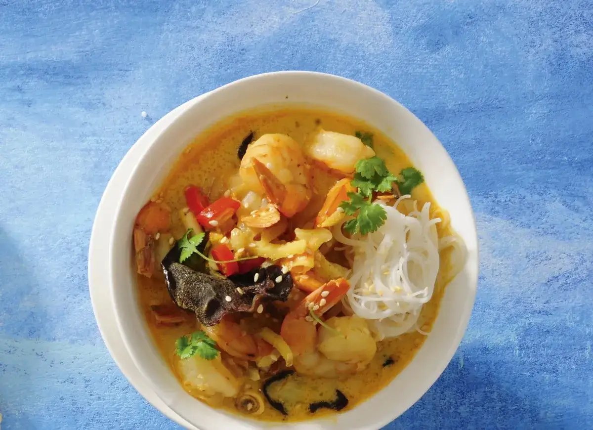 Aromatyczna zupa z krewetkami na mleku kokosowym z makaronem ryżowym, papryczką chili i kolendrą.